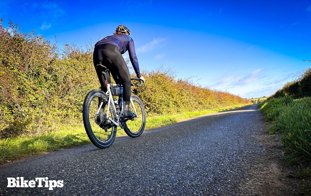 Riding my gravel bike on an asphalt road while randonneuring.