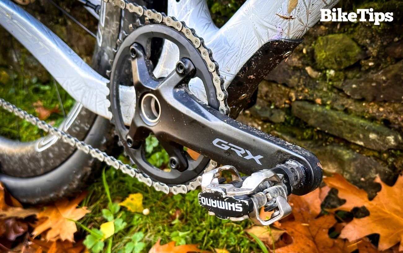 Close-up of an SPD pedal on a white gravel bike.