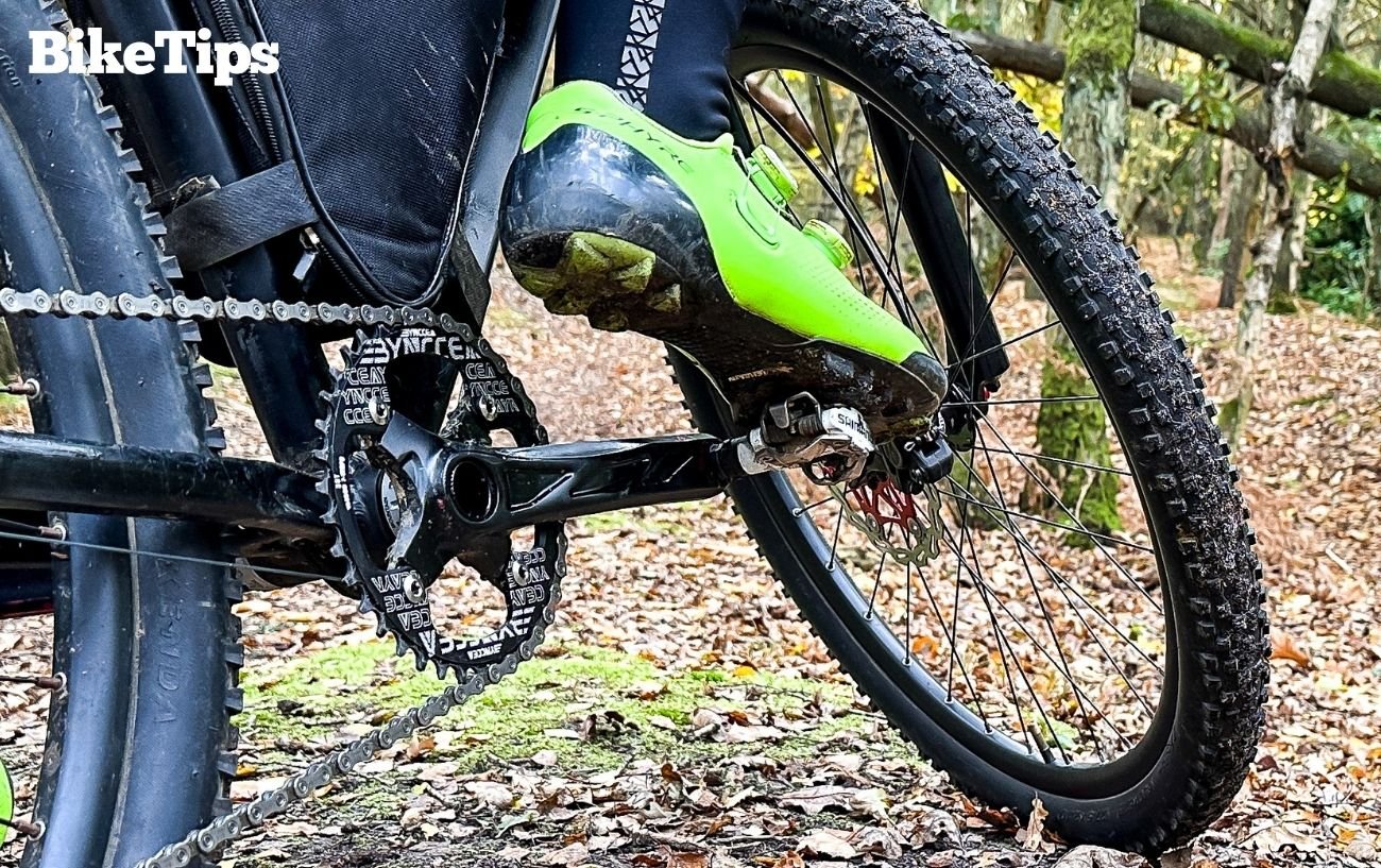 Robbie rides in green cycling shoes and SPD cleats on a mountain bike.
