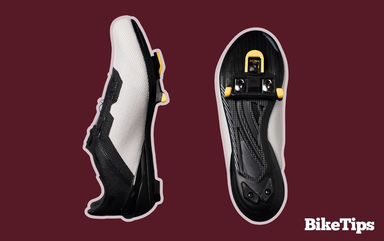 Shimano SPD-SL cleats fitted to a white cycling shoe on a burgundy background.