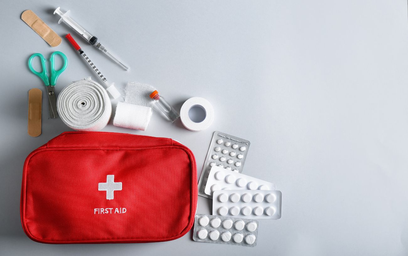 An unpacked first aid kit for triathletes sits on a white table.