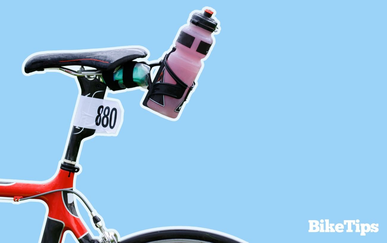 A red triathlon bike with a pink bottle attached to the seat post.