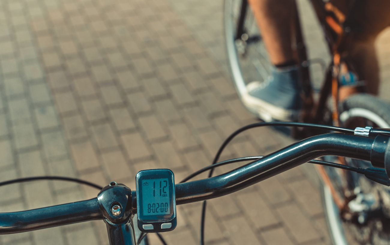 An old school bicycle odometer attached to handlebars.