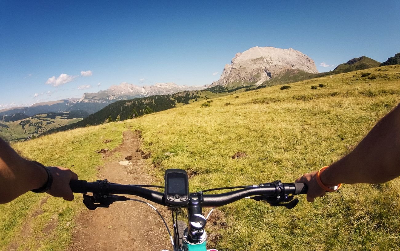 A mountain biker with a bicycle computer attached to the handlebars.