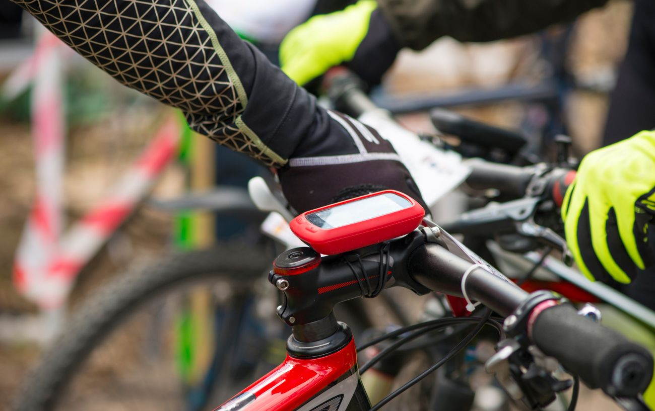 A red bike computer attached to a bicycle stem.