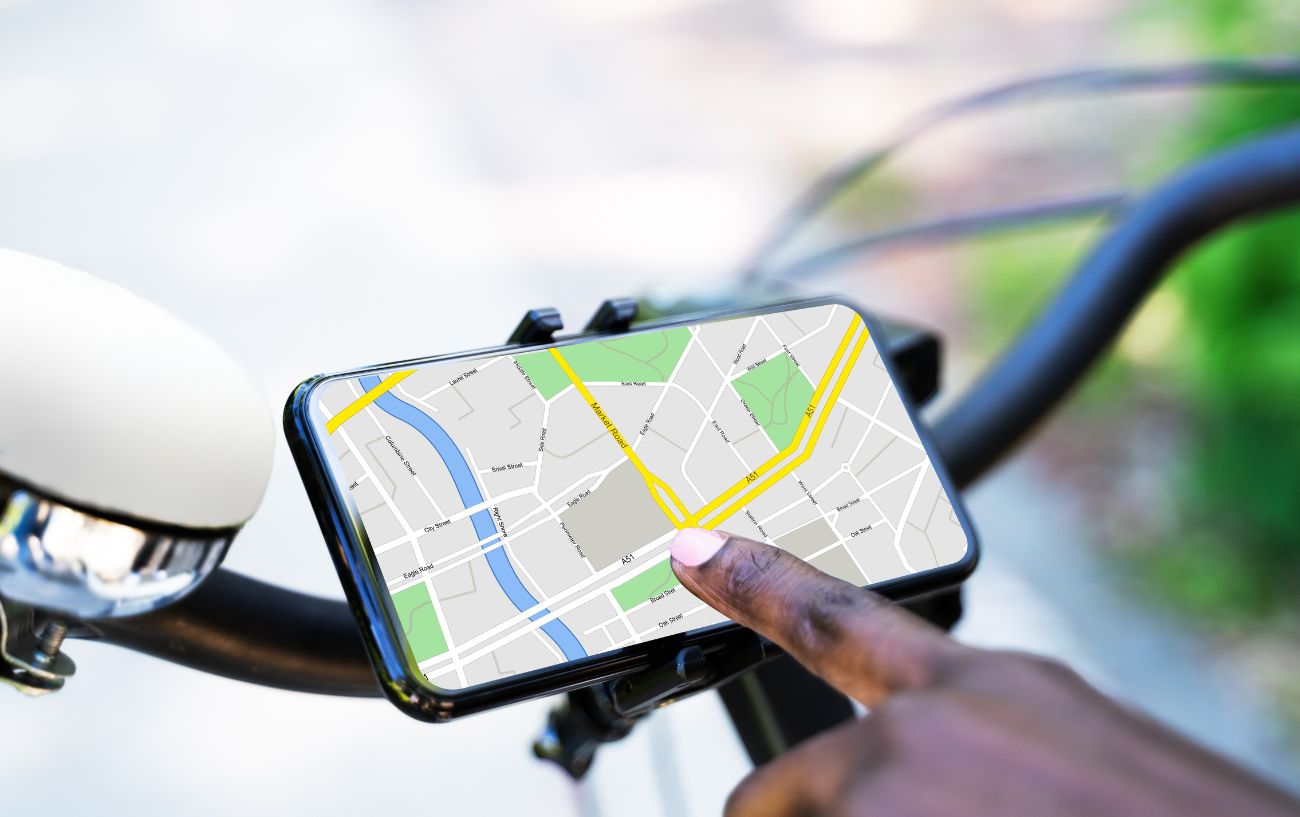 A phone attached to a bicycle showing a map.