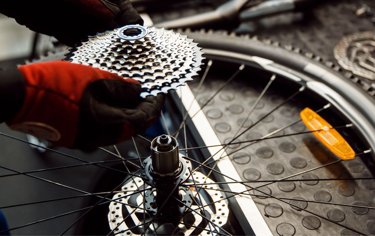 A bike mechanic slots a cassette onto a freehub body.