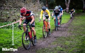 Cyclocross racers riding in the mud through a field.