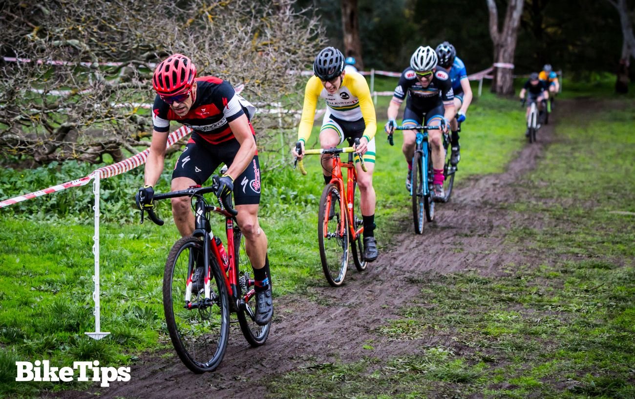 Cyclocross racers riding in the mud through a field.