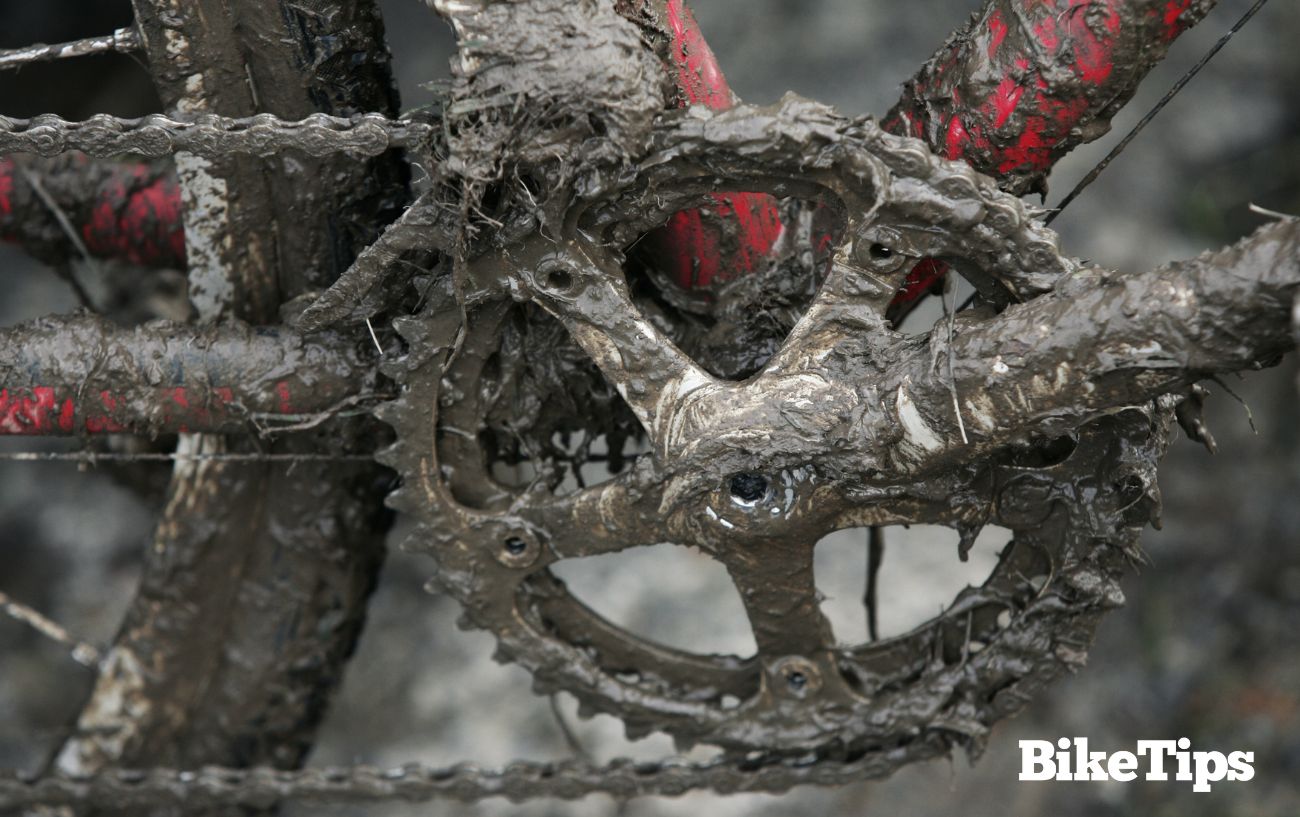 A crankset caked in mud after riding off-road.
