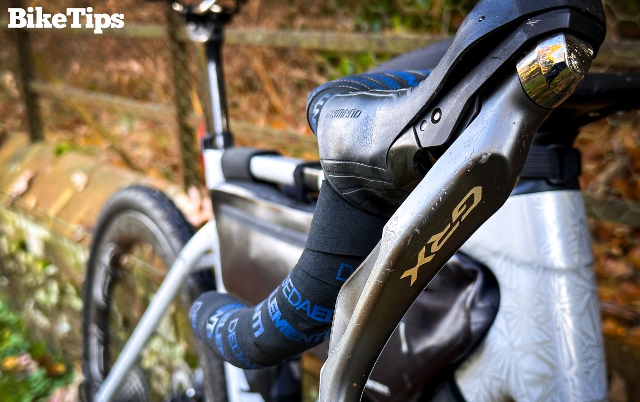 Drop handlebars on a white gravel bike.