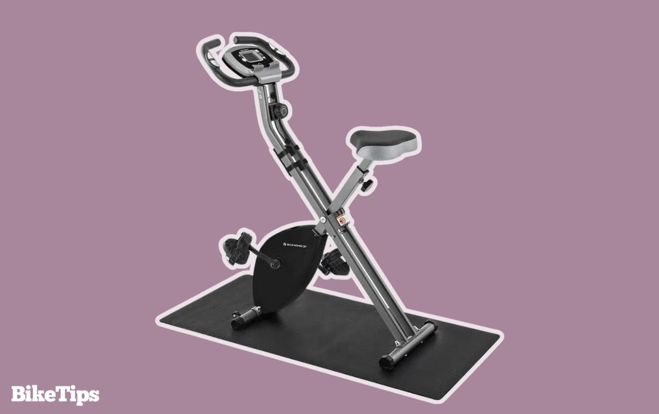 Folding exercise bike on a purple background.