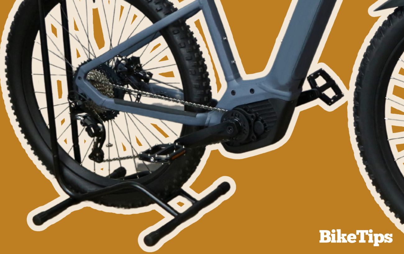 How do electric bikes work? This graphic shows a mid-drive electric bike on a brown background.