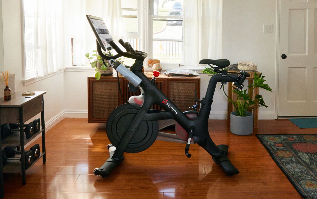 Peloton bike which has been moved into a room with a wooden floor.