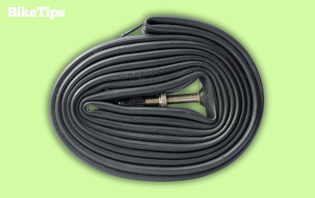 A road bike inner tube wrapped up with a green background.