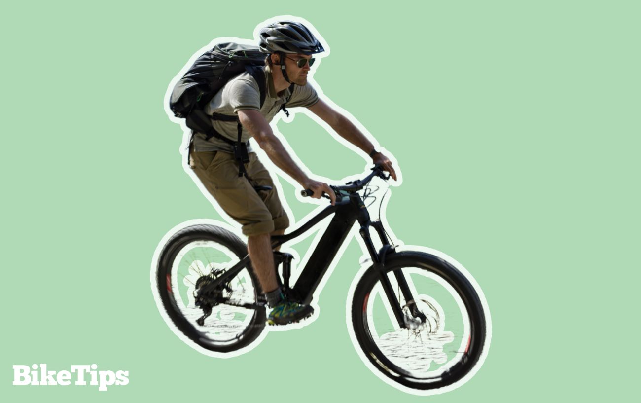 A man rides an electric mountain bike on a green background.