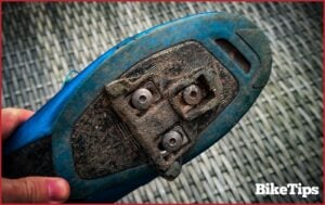 An SPD-SL cleat on the bottom of a cycling shoe.