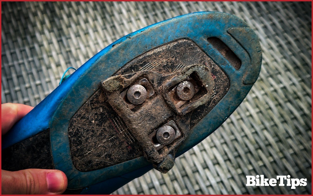 An SPD-SL cleat on the bottom of a cycling shoe.