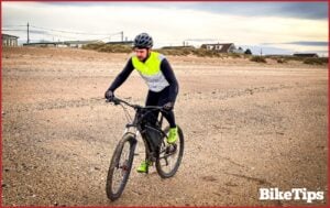 A cyclist riding on the beach.
