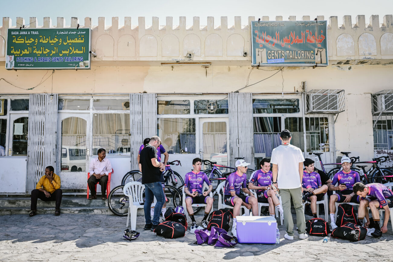 A group of cyclists relaxing with their soigneur before a race.
