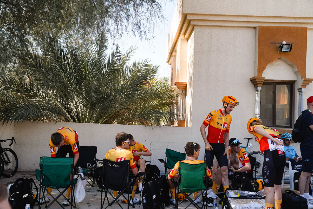 A group of cyclists relaxing with their soigneur after a race.
