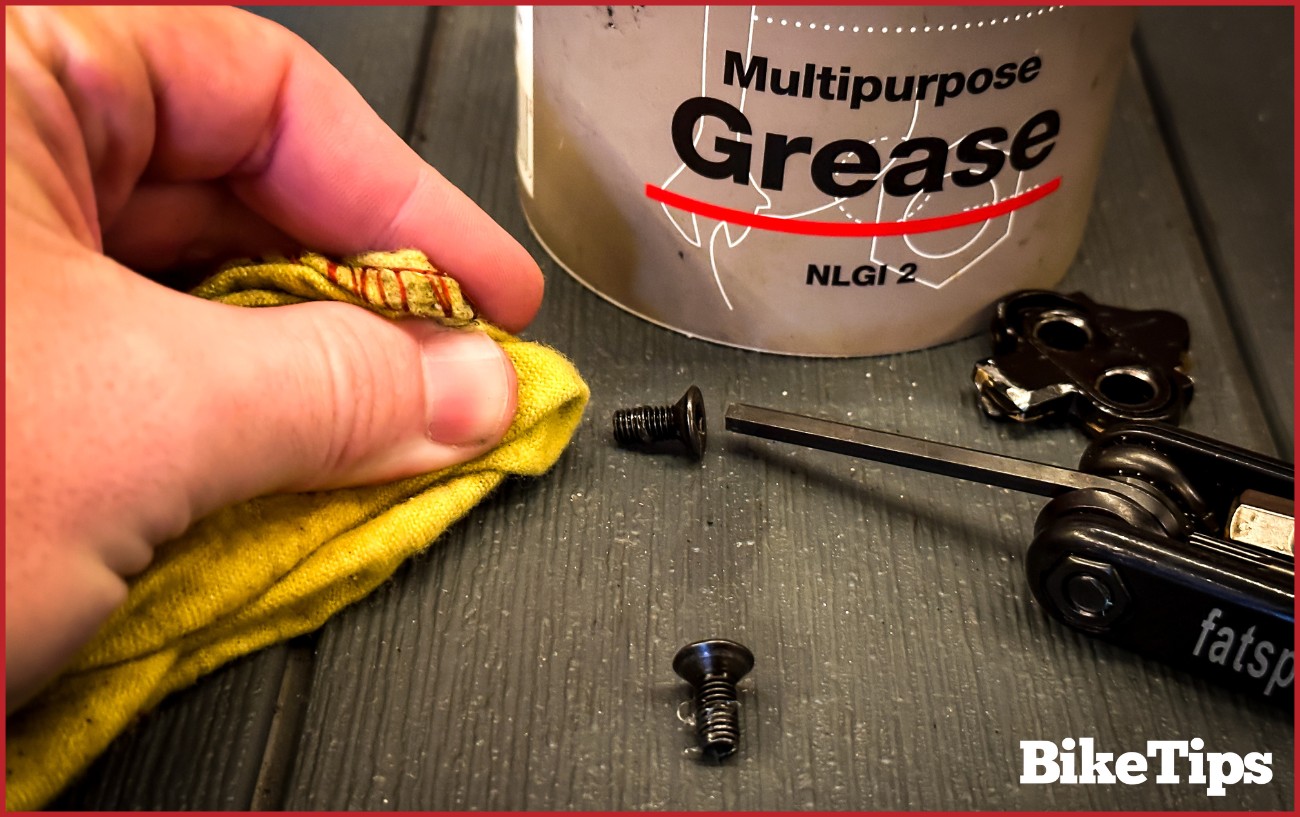 Greasing cleat threads.