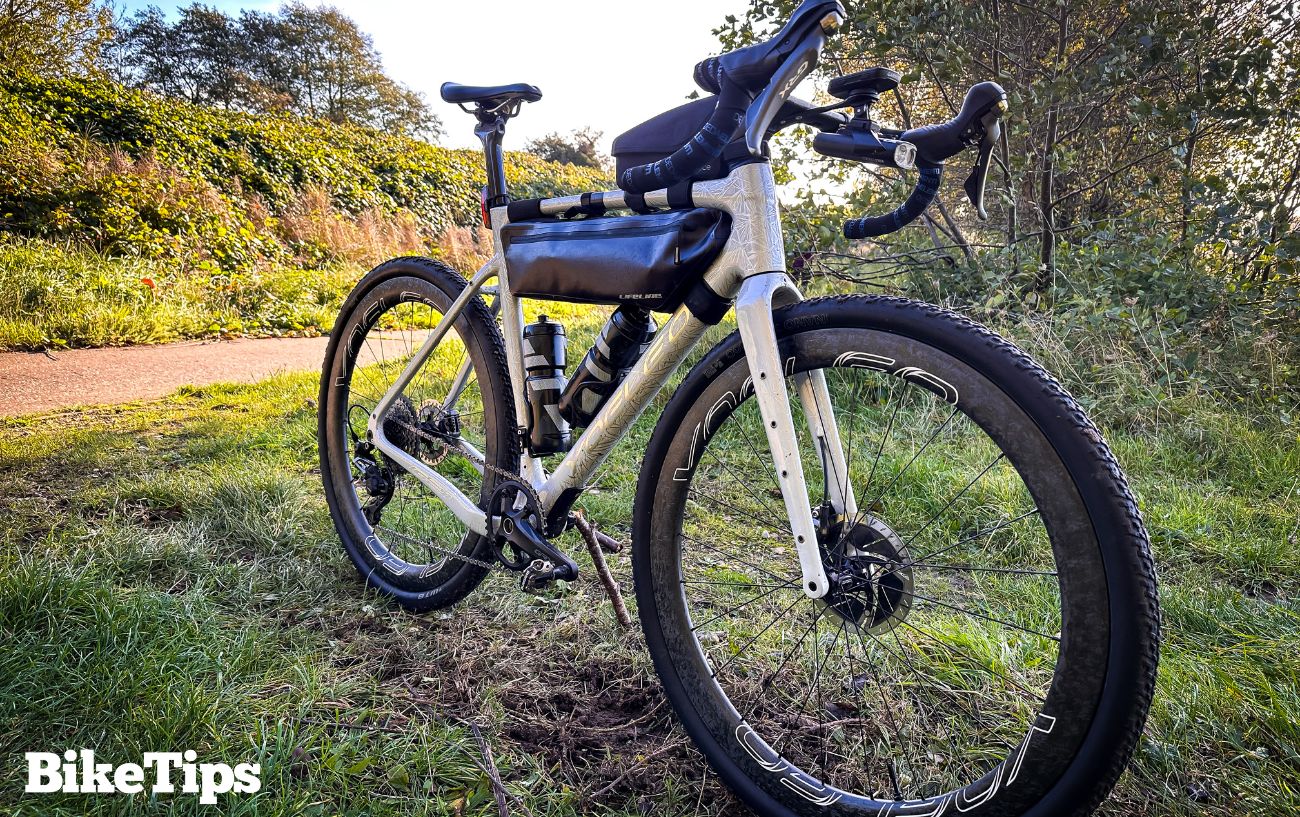 A white gravel bike sits on grass.