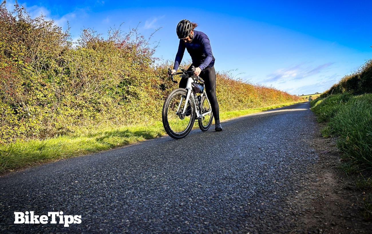 Robbie learns how to ride a bike as an adult on a tarmac road.
