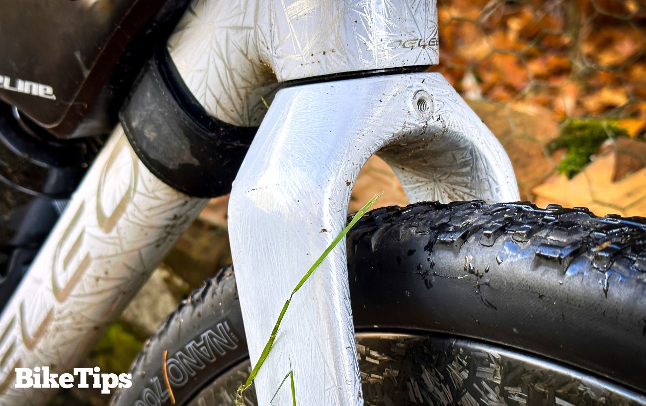 A gravel bike tyre with white bicycle forks.