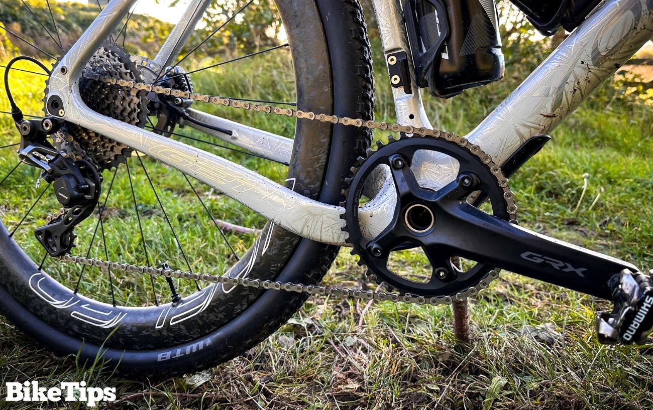 White gravel bike with a silver bike chain.