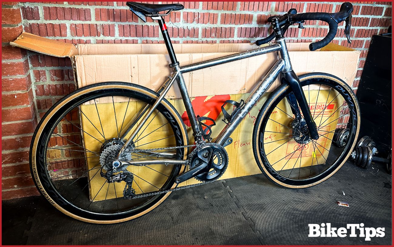 How to assemble a bike, showing an assembled grey road bike next to a bike box.