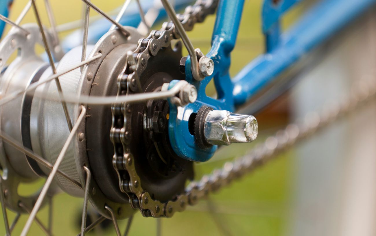 Close-up of an internal gear hub on a blue bike.