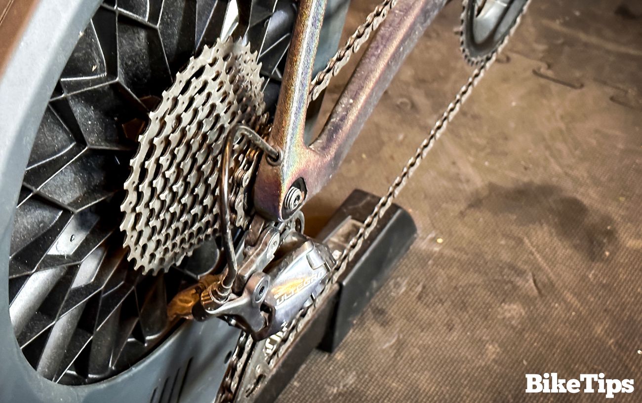 Silver bike chain on a bike in a turbo trainer.